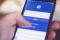 Detalle de una mano accediendo a Facebook desde un dispositivo móvil